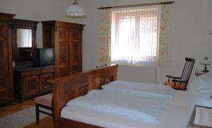 a bedroom with a bed and a tv and a bed sidx sidx sidx at Frühstückspension Kirchenwirt in Obervellach +16 photos