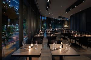 a restaurant with tables and chairs with wine glasses at Shilla Stay Mapo Hongdae in Seoul