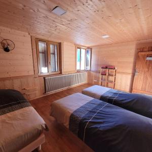 um quarto com 2 camas num chalé de madeira em chalet des cyclistes em La Bresse