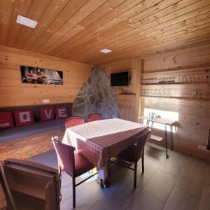 a dining room with a table and a stone fireplace at chalet des cyclistes in La Bresse