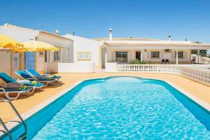 a swimming pool in front of a house at Casa Luz in Lagoa