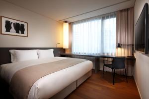 a hotel room with a large bed and a desk at Shilla Stay Mapo Hongdae in Seoul