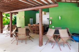 una sala da pranzo con parete verde e tavolo e sedie di Praia do Forte Kauai a Praia do Forte