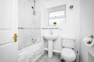 Baño blanco con aseo y lavamanos en Stunning Two Bedroom House - Parking & Garden - Near Birmingham City Centre - 55H en Birmingham