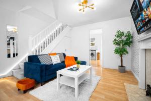 a living room with a blue couch and a white table at Stunning Two Bedroom House - Parking & Garden - Near Birmingham City Centre - 55H in Birmingham