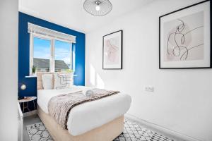 a bedroom with a bed with blue walls and a window at Stunning Two Bedroom House - Parking & Garden - Near Birmingham City Centre - 55H in Birmingham