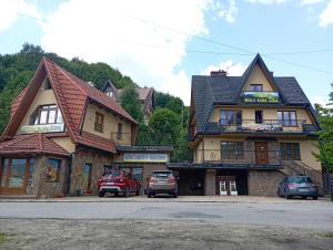 a building with cars parked in front of it at Willa Babia Góra in Zawoja