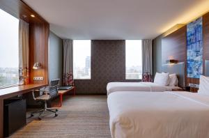 a hotel room with two beds and a desk at Sky Loft Hotel Kyiv by Rixwell International in Kyiv