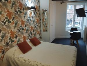 1 dormitorio con 1 cama y papel pintado con motivos florales en Les Cascades - Hôtel de Charme, en Honfleur