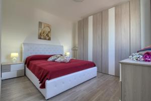 a bedroom with a white bed with a red blanket at Enjoy Leuca Mare in Castrignano del Capo