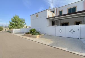 a house with a white fence and a driveway at Enjoy Leuca Mare in Castrignano del Capo