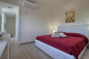 a white bedroom with a bed with a red blanket at Enjoy Leuca Mare in Castrignano del Capo