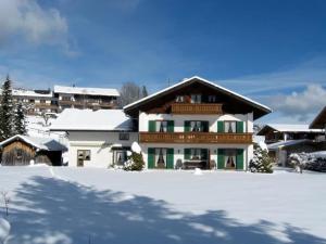 a house with snow on the ground in front at Alpenblick Tilly - Fewo Barmsee 2 in Krün