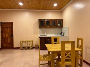 a kitchen with a wooden table and wooden cabinets at Palm Path Resort in Jaffna