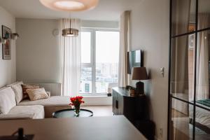 a living room with a couch and a window at Apartament z widokiem na Rzeszów in Rzeszów