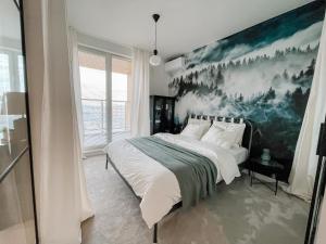 Apartament z widokiem na Rzeszów في جيشوف: غرفة نوم بسرير مع لوحة على الحائط