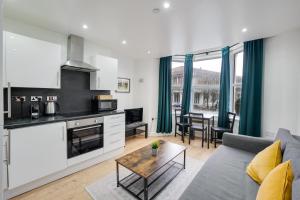 a kitchen and living room with a couch and a table at Relax in a modern Cardiff home by the City Centre & Bute Park in Cardiff +16 photos