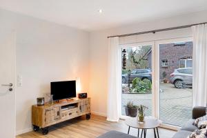 sala de estar con TV de pantalla plana sobre una mesa de madera en Ferienhaus Im Grünen, en Varel