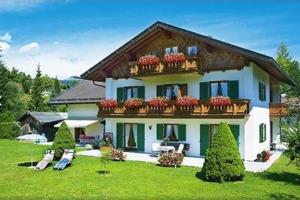a large house with flower boxes on the balcony at Walchensee - Alpenblick Tilly in Krün