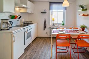 een keuken met een tafel en oranje stoelen bij Wohnung 4 