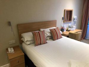 een slaapkamer met een groot wit bed met 2 kussens bij Croit Anna Hotel in Fort William