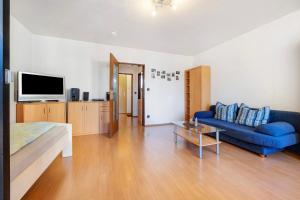 uma sala de estar com um sofá azul e uma televisão em Appartement Björn Schuhknecht em Hanôver