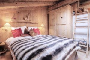 a teddy bear sitting on a bed in a bedroom at Duplex Chaleureux au Cœur de Megève 2 p in Megève