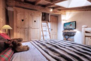 a teddy bear sitting on a bed in a bedroom at Duplex Chaleureux au Cœur de Megève 2 p in Megève