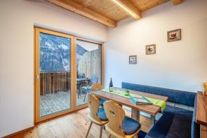 a living room with a blue couch and a table and chairs at Kreuzplonhof Apt Dorfblick in Luson
