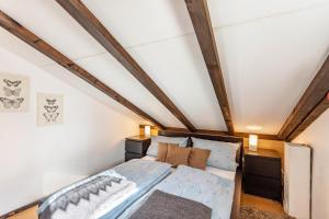 - une petite chambre mansardée avec un lit et des poutres apparentes dans l'établissement Ferienhaus Vorauf - Rosenbauer, à Siegsdorf