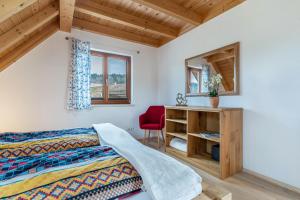 Schlafzimmer mit einem Bett, einem Schreibtisch und einem roten Stuhl in der Unterkunft Vorderbühlhof in Oppenau