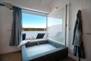 a bath tub in a room with a large window at Stylish town house in Silves in Silves