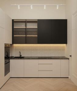 a large kitchen with white cabinets and a sink at Strzelecka apartment in Kraków
