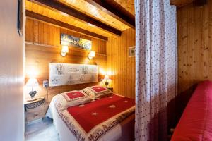 1 dormitorio con 1 cama en una habitación con paredes de madera en Studio Sabot de Vénus, en Thônes