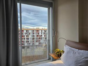 1 dormitorio con ventana y vistas a un edificio en Apartaments Els Quimics en Girona