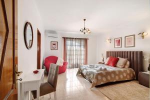 a bedroom with a bed and a desk and a chair at Casa Judite in Lagoa