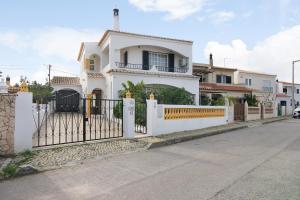 a white house with a white fence at Casa Judite in Lagoa