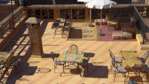 a patio with chairs and tables and an umbrella at Kasbah Du Roches Armed in Imlil