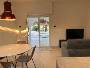 a living room with a table and a couch at Uliveus - Villa Duna fronte mare in Faccia di Trippa