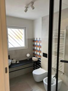a bathroom with a toilet and a sink and a window at Uliveus - Villa Duna fronte mare in Faccia di Trippa +45 photos