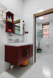 a bathroom with a sink and a mirror at 凤凰古城宝庆民宿 in Fenghuang County