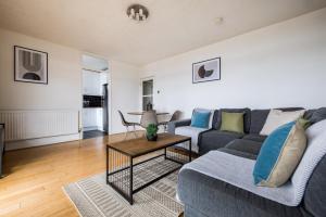 een woonkamer met een bank en een tafel bij The Bermondsey Apartment in Londen