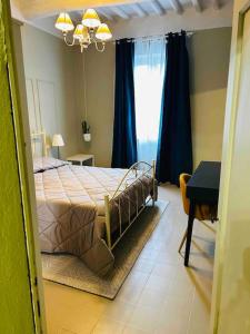 a bedroom with a bed with blue curtains and a table at Antica dimora in Borgo a Buggiano