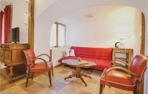 uma sala de estar com um sofá vermelho e uma mesa em Amazing Apartment In Les Salles-du-gardon With 2 Bedrooms, Outdoor Swimming Pool And Wifi em Soustelle