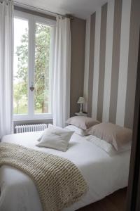 2 camas num quarto com uma janela em Grand Gîte Atypique au cœur du Pays des Châteaux em La Chaussée-Saint-Victor