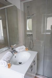y baño con lavabo blanco y ducha. en Grand Gîte Atypique au cœur du Pays des Châteaux, en La Chaussée-Saint-Victor