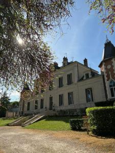 duży biały dom ze słońcem świecącym na nim w obiekcie Grand Gîte Atypique au cœur du Pays des Châteaux w mieście La Chaussée-Saint-Victor