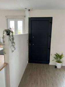 uma porta preta num quarto branco com plantas em House Near EPFL/Unil/Renens Gare/Lausanne em Ecublens