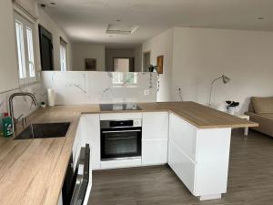 a kitchen with white cabinets and a counter top at House Near EPFL/Unil/Renens Gare/Lausanne in Ecublens