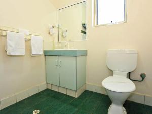 a white toilet sitting next to a sink in a bathroom at Abrolhos Reef Lodge in Geraldton